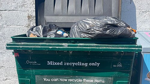 Rubbish dumped in communal recycling bins